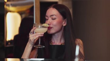Gülümseyen güzel bir kadın Margarita kokteylinin tadını çıkarıyor. Lüks bir barda arkadaşlarla ya da çiftlerle canlı sohbetler yapıyor. Canlı bir gece kulübünde bir an yaratıyor. Vinosity.