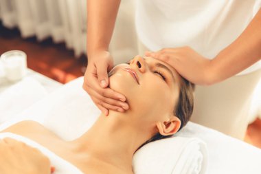 Kafkasyalı kadın stres önleyici kafa masajından ve lüks tatil beldesi ya da otel spa salonundaki modern ışık ortamında yüz güzelliği eğlencelerini şımartmaktan hoşlanıyor. Sessiz.