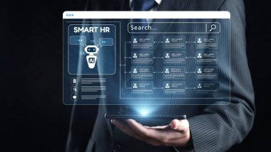 Bir işadamı, işe alım ve işçi alma süreçlerini etkili bir şekilde geliştirmek için tasarlanmış yapay zeka güdümlü bir insan kaynakları yönetim arayüzünü gösteren dijital bir cihaz tutuyor. Dörtgen