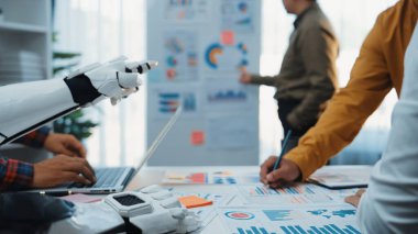 Etkili iş stratejileri için teknoloji entegrasyonunu vurgulayan, veri görselleştirme unsurları olan insanlar ve robotlar arasındaki işbirliğini gösteren modern bir ofis sahnesi. Noogenesis