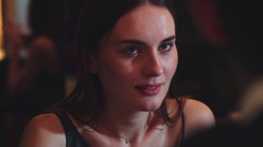 Odaklanmış güzel, çekici bir kadının portresi yatay manzaralı arkadaşlarla sohbet ediyor. Gece kulübünde sosyetik atmosferde doğal yüz güzelliği yakalamak. Vinosity.