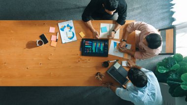 Yönetici, toplantı odasındaki meslektaşlarına mali grafiği açıklar. Farklı pazarlama ekibinin tabletle masada otururken fikir ve planlama stratejisini en üst düzeyde paylaşması. Cemaat.