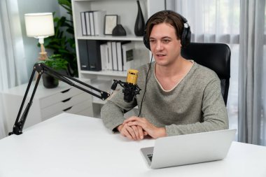 Sunucu kanalı, gülümseyen akıllı yayıncı kaydı, senaryosu ve akıllı telefonuyla sosyal medyada sohbet programı, kulaklık takarak modern ev stüdyosundaki video flamalarını kaydediyor. Bireysel.