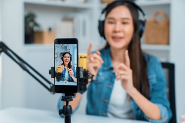 Yaratıcı yayıncı genç ve güzel Asyalı 'nın sunucu kanalındaki seçici odaklı telefon stüdyodaki dinleyiciyle günlük hayatta pazarlamayı veya danışmanı desteklemek için online olarak konuşuyor. Taktik.