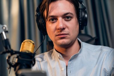 Sunucu kanalı akıllı yayıncı canlı sosyal medyada kamera önünde yüz portresi yapıyor. Etkilenen yayıncı, modern ofis stüdyosunda kulaklık takıyor. Bireysel.