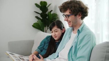 Beyaz bir baba ve tatlı bir kız kanepede otururken masal kitabı okuyorlar. Mutlu bir baba, sevimli bir Amerikan çocuğuna, birlikte zaman geçirirken hayal gücünün gelişmesi için hikaye anlatıyor. Pedagoji.