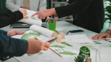 Çeşitli profesyonellerden oluşan bir grup, stratejik iş kararları ve büyümeyi yönlendirmek için grafik ve çizelgeleri gözden geçirmek üzere modern bir ofiste ortak bir toplantı düzenliyor. SACTR