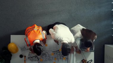 Akıllı mimar ve yetenekli inşaat mühendisi ekibinin, bina inşaatı için birlikte çalışırken proje, ekipman ve güvenlik kaskıyla toplantı masasında durmasının en iyi görüntüsü. Hizalama.