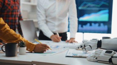 İş analizi, çizelgeler ve takım çalışmasını ve teknolojiyi yansıtan kağıtlar sergilenmesi için insan eliyle çalışan modern bir ofis sahnesi.