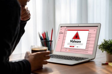 Cyber attacking concept. Malware alert showing on computer screen display scam and threat detection on computer system or online server to be removed snugly.