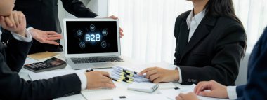 İş adamı B2B peyzajında geziniyor, iş-iş bağlantılarını geliştirmek için kullanım teknolojisi kullanıyor. B2B etkileşimini yeniden şekillendiren keşifler, iş-iş stratejilerinde yenilikleri yönlendiren araçlar. canlı