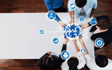 Modern ofis ortamında takım çalışması ve teknolojiyi temsil etmek için bulmaca grafikleri kullanarak iş stratejileri üzerinde işbirliği yapan çeşitli profesyonellerin hava görüşü. Dostluk