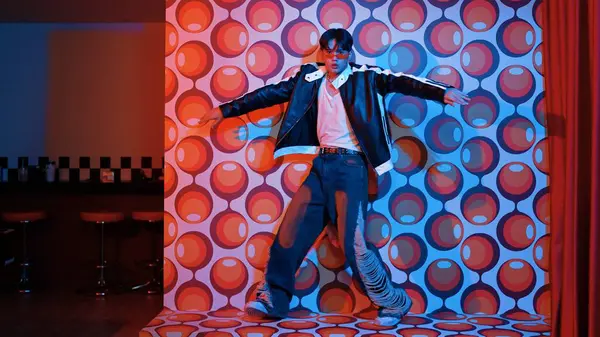 Asyalı break dansçı serbest stile geçiyor ve balon arka planlı kameraya bakıyor. Profesyonel hippi gündelik kıyafet giyer ve gözlük takar. Mutluluk.