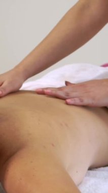 Rahat bir kadın profesyonel masaj terapistiyle lüks kaplıcalarda masaj yaptırıyor. Sağlık, şifa ve rahatlama konsepti.