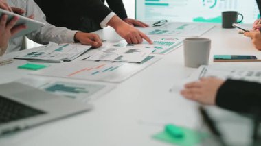 Mesleki bir çalışma alanında ortaklaşa bir iş toplantısı. Çeşitli bir ekibin tablodaki çizelgeleri ve grafikleri analiz ettiği, strateji ve sezgileri tartıştığı bir toplantı. SACTR