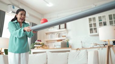 Büyükannenin elinde boru var ve göz, el koordinasyonunu geliştirmek ya da odaklanma ve konsantrasyonu arttırmak için top yuvarlama oyunu oynuyor. Yaşlı çift stresi azaltıyor. Sağlık hizmetleri. Myrmidon.