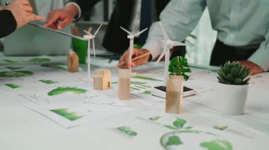 Yenilenebilir enerji stratejileri, rüzgar türbini modelleri ve yeşil santralleri modern bir ofiste gerçekleştirilen yoğun planlama oturumunda çeşitli iş ekipleri işbirliği yapıyor. SACTR