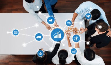 Çeşitli bir ekip, stratejik iş büyümesi ve operasyonel verimliliği artırmak için teknolojiden ve veri analizinden yararlanan modern bir ofis masasında işbirliği yapıyor. Dostluk