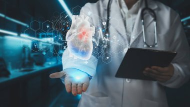 Elinde tablet olan ve kalp hologramını tutan zeki doktorlara yaklaş. Kalp ameliyatına hazırlanırken laboratuvar önlüğü kontrolünde ve kalp semptomu teşhisinde uzman bir tıp çalışanı. Kardiyoloji. İyileştirici.
