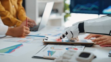 Çağdaş bir ofis içinde finansal verilerin analiz edilmesinde profesyonellere yardımcı olan robotik kol, teknoloji ve iş dünyasının verimliliğini artırmak için füzyonunu örnek göstermektedir.