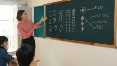 Zeki öğretmen sınıfta fikri açıklarken sevimli öğrenci ödevlerini kontrol ediyor. Not defterine bakıp matematik teorisinden çocuğa bahsederken sınıfta dolaşan çekici bir eğitmen. Pedagoji.