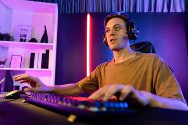 Kazanmak için çevrimiçi oyun oynayan akıllı flama makinesinin sunucu kanalı, neon ışıklı odada seçilen takım yarışması için izleyicilerle birlikte canlı yayında canlı yayında kulaklık takıyor. Bireysel.