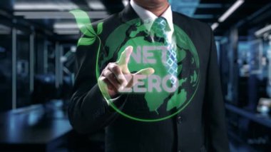 Bir işadamı, sürdürülebilirlik, çevresel sorumluluk ve yenilikçi stratejileri vurgulayarak, net hedefleri olan dijital ekranlı bir takım elbiseye güvenerek ayakta duruyor. Dörtgen