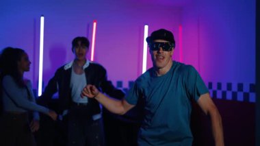 Kameranın önünde dans eden yetenekli break dansçı farklı arkadaşları pop ya da hip hop müziği dinlemek için arkada dans ediyor. Çekici performans ekibi kameraya doğru hareketli hareketler sergiliyor. Mutluluk.
