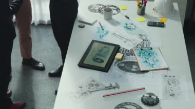 Gündelik kıyafet giymiş profesyonel mühendis ekibi masada teçhizatlı, hesap makineli, yapışkan notlu türbin motor yapısı hakkında konuşuyor. Bir grup teknisyen toplantıda el sıkışıyor. Hizalama.