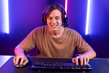 Kazanmak için çevrimiçi oyun oynayan akıllı flama makinesinin sunucu kanalı, neon ışıklı odada seçilen takım yarışması için izleyicilerle birlikte canlı yayında canlı yayında kulaklık takıyor. Bireysel.