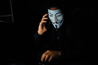 Beyaz gülümseyen isimsiz suçlu maskesi kurbana sesleniyor, kişisel bilgileri hacklemeye ikna ediyor, veri sunucu sistemindeki bilgisayar korsanlarının kullandığı şifreleme programını paylaşıyor. Tahmin et..