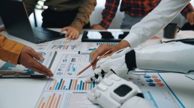 Robot el olarak ekip çalışması veri raporlarını analiz etmede yardımcı oluyor. Modern ofis, teknolojiyle işbirliği ve yenilik sergiliyor. Noogenesis