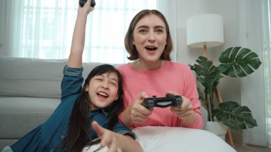 Mutlu çocuk oyun oynuyor ve oturma odasında otururken annesini kazanıyor. Çekici kız elini havaya kaldırıp şarapları kutlarken beyaz bir anneyle vakit geçiriyor. Pedagoji.