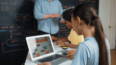 Öğretmenler kodlama sistemini öğretirken, farklı akademik öğrenciler STEM teknoloji sınıfında ana tahtayı dizüstü bilgisayar programlama programlama komut veya mühendislik koduyla düzeltiyorlar. Öğretim.