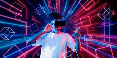 VR gözlük takan zeki bir genç ve geometrik şekil konusunda heyecanlı. Afrikalı oyuncu gündelik kıyafet giyiyor ve artırılmış gerçeklik teknolojisi kullanırken parlak ışık rengiyle çevrili. Yaratıcılık.