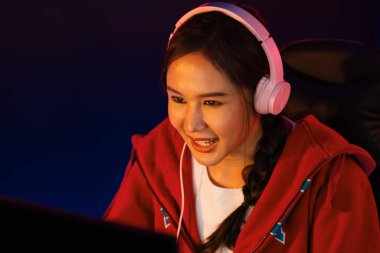 Portre sunucusu güzel Asyalı kız flamasının çevrimiçi oyun oynaması kulaklık takması pastel renkli konuşmalar izleyici medyası ile çevrimiçi. Esport yetenekli takım oyuncuları neon mavi odada. Taktik.