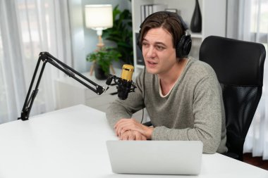 Sunucu kanalı, gülümseyen akıllı yayıncı kaydı, senaryosu ve akıllı telefonuyla sosyal medyada sohbet programı, kulaklık takarak modern ev stüdyosundaki video flamalarını kaydediyor. Bireysel.