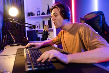 Kazanmak için çevrimiçi oyun oynayan akıllı flama makinesinin sunucu kanalı, neon ışıklı odada seçilen takım yarışması için izleyicilerle birlikte canlı yayında canlı yayında kulaklık takıyor. Bireysel.