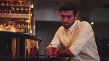 Beyaz tişörtlü, kokteyl içen zeki bir adam. Eski moda parti içkisi. Arkadaşlarını ya da çiftlerini cuma gecesi kulüpte bekleyen lüks bir tezgah barda bekliyor. Vinosity.