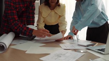 Mimarlık ve güvenlik mühendisi, modern ofiste dizüstü bilgisayarda mimari belge ve ahşap blokla sergilenen planlar hakkında tartıştı. - Yakın çekim. Tanımlama.