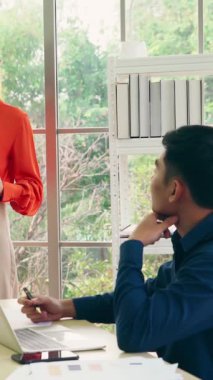 İş adamları ofisteki proje planlama kurulunda çalışıyor ve proje gelişimini analiz etmek için iş arkadaşlarıyla sohbet ediyorlar. Düzenli olması için cam duvara yapıştırılmış yapışkan notlar kullanıyorlar. .