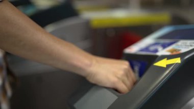 Çok kültürlü yolcuların elleri turnikelere madeni para koydu ve içeri girmek için gökyüzü treni, metro gibi insanlarla çevrili toplu taşıma araçlarını kullandı. Çalışma rutini. Sevinçli..