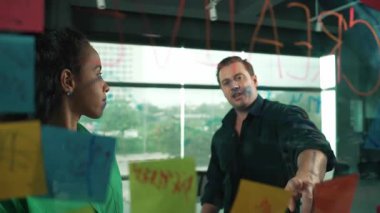 Yetenekli işadamı pazarlama fikrini cam duvardaki proje yöneticisine sundu. Yönetici projeyi yatırımcıya açıklıyor. Zeki iş adamları birlikte çalışıyor, beyin fırtınası yapıyorlar. Yönlendirici.