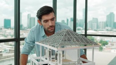 Modern ofiste gökdelen ve şehir manzaralı kalem ölçme modeli çatı uzunluğu kullanan profesyonel mimar mühendisi. Yetenekli proje yöneticisi ya da işadamı ev inşaatını kontrol ediyor. İzleme