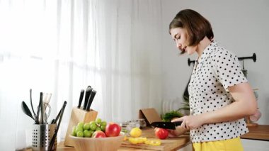 Çekici beyaz anne salata yapmak için taze sebze doğruyor. Mutlu enerjik akıllı anne kahvaltıda sağlıklı yemek pişirirken modern mutfakta çalışıyor. Yemek hazırlama konsepti. Pedagoji.