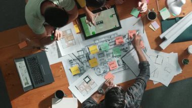 Pazarlama ekibi tasarım planlarken yöneticinin planlarını yukarıdan aşağıya incelemek. Mimar mühendisin birlikte çalıştığı, fikir paylaştığı ve proje planına not aldığı hava görüşü. Sempozyum.