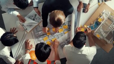 Yetenekli mühendis ekibinin proje planına bakarken konuştuğu en üst seviye görüntü. Birlikte çalışan ve mühendislik inşaatı için plan yapan bir grup akıllı iç mimar. Hizalama.