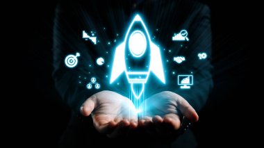 Büyümeyi ve teknolojiyi sembolize eden parlayan roket ile iş dünyasındaki yeniliklerin çarpıcı görsel temsili, karanlık bir zemin karşısında el ele tutuştu. Dörtgen