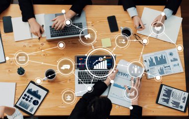 Çeşitli profesyonellerden oluşan bir grup, dizüstü bilgisayar ve kağıtlarda gösterilen grafik ve grafiklerle birlikte verileri analiz ederek, yenilikleri teşvik eden bir ortak iş toplantısı düzenliyor. Dostluk