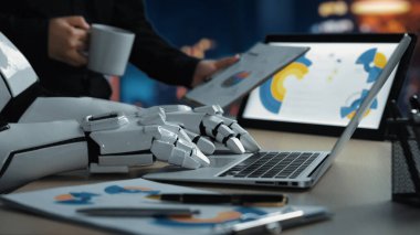 Bu resim, teknolojinin modern işbirliğindeki rolünü sembolize eden, iş raporlarını gösteren bir dizüstü bilgisayarla etkileşime giren yenilikçi bir çalışma alanını gösteriyor.